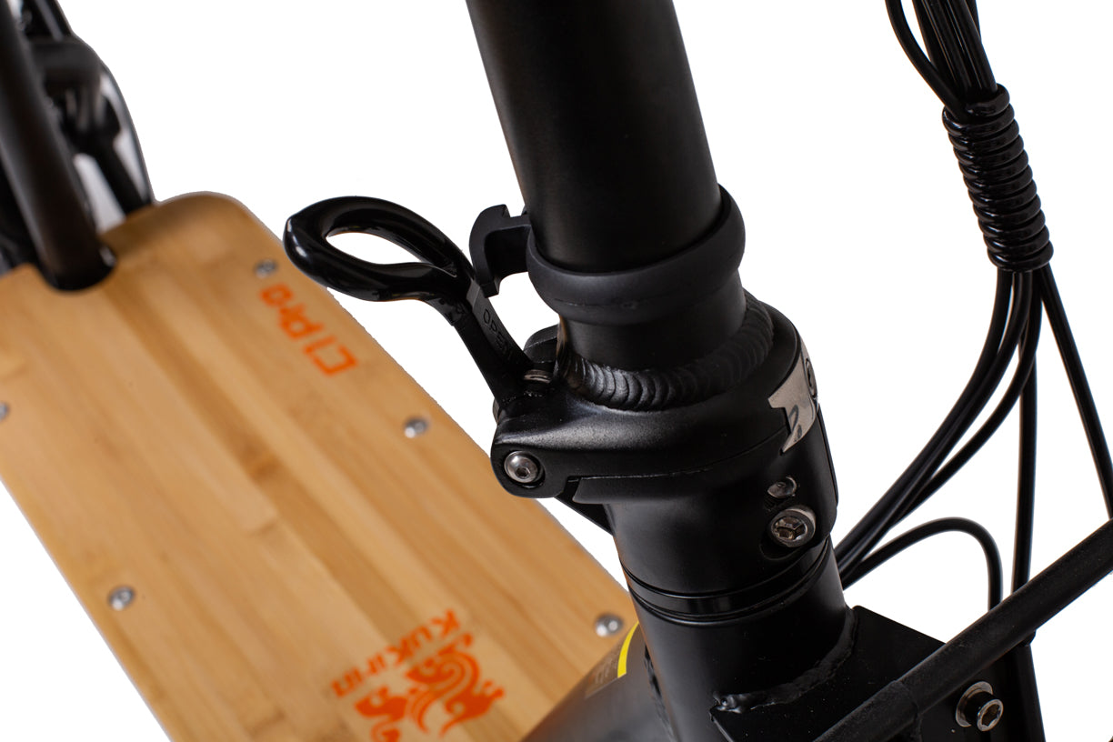 Close-up of a wooden skateboard with black trucks and wires on a white background kukirin c1 pro electric scooter